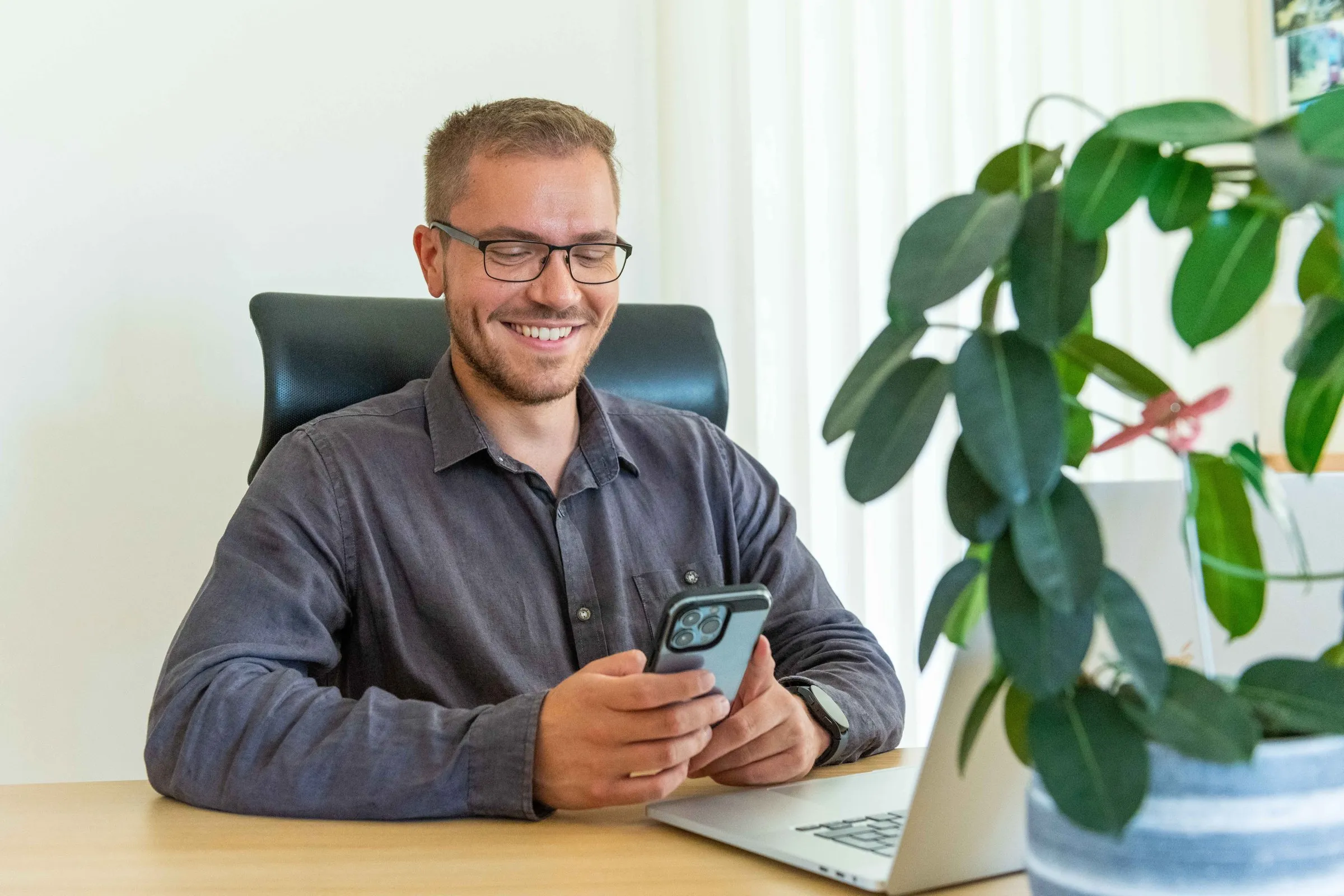 Mitarbeiter hält die Timework-App am Smartphone, mobile Erfassung unterwegs